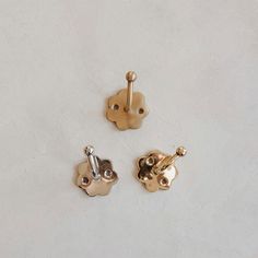 three pairs of gold and silver cufflinks on a white surface with no background