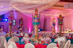 a banquet hall decorated with white linens and colorful decorations