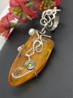 "ARTISAN AMBER GEMSTONE PENDANT Hand-made Sterling Silver. Stones used: Baltic Amber, Pearls, Peridot, Amethyst. Height - 73mm, Width - 30mm. Unique Handcrafted One-of a-kind Design Pendant Each Piece of Jewelry in my Collection is Absolutely One of a Kind! When you start wearing a piece of my jewelry you will fall in love with it more and more each day and feel that good Energy and Love that I pass into it while creating this piece of Art. A piece of Art created for you to be inspired and love Elegant Gemstone Pendant Beads, Fusion Style Pearl Pendant Jewelry As Gift, Elegant Gemstone Pendant, Fusion Style Pearl Pendant Jewelry For Gift, Amber Pendant Jewelry For Wedding, Unique Pendant Beads For Jewelry Making, Yellow Pearl Pendant Jewelry, Unique Amber Gemstone Beads And Cabochons, Artisan Beads And Cabochons Pendant For Gift