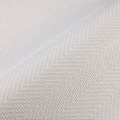 a close up view of the fabric on a white bed sheet with grey herringbones