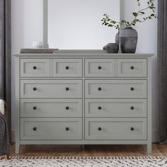 a bedroom with a large gray dresser and mirror