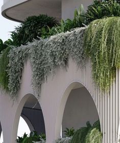 a building with plants growing on the side of it's wall and arches in front of it