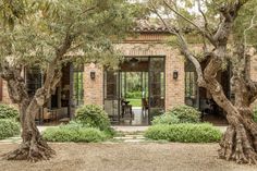 an outdoor area with trees and bushes surrounding the entrance to a brick building surrounded by greenery