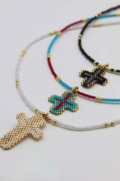 three necklaces with cross charms and beads on white background, close up view photo