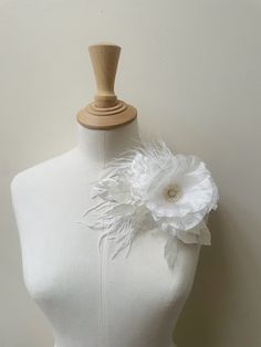 a mannequin with a white flower on it