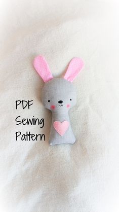 a stuffed animal with pink ears sitting on top of a white bedding sheet that says pde sewing pattern