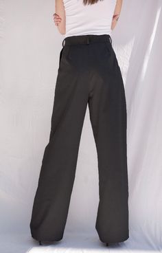 The Josephine Pants are our modern high waisted twist on the regular work trousers, complete with a chic fabric belt that stretches from one seam to the other and pleated details that will make any waist look like an hourglass. Pair with the Josephine Vest and Josephine Trench Coat for a head to toe monochromatic look. These sustainable pants are tailor made and on demand. It takes us 3 hours to make these trousers. Check out the pricing transparency HERE. PLEASE ALLOW 1-3 BUSINESS DAYS FOR PROD Tailored High Waist Work Pants, High-waisted Dress Pants With Belt Loops For Work, Tailored High-waist Pants For Workwear, Formal Wide Leg Bottoms With Belted Cuffs, Chic Work Pants With Belt Loops, Chic High Waist Wide Leg Pants With Belted Cuffs, Formal Wide-leg Bottoms With Belted Cuffs, High-waisted Work Pants With Belt Loops, Formal Wide-leg Pants With Belted Cuffs