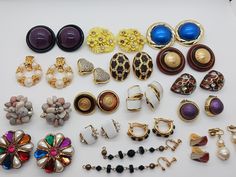 many different types of earrings on a white surface