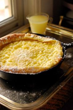 a pie sitting on top of a stove next to a glass container filled with orange juice