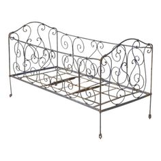 a metal bed frame with wheels on the bottom and sides, in an ornate pattern