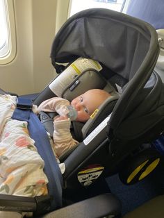 a baby in a car seat on an airplane