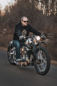 a man riding on the back of a silver motorcycle