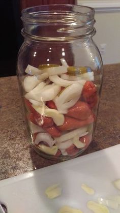 a glass jar filled with sliced onions on top of a counter