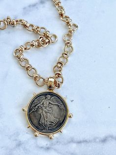 This beautiful French commemorative coin hangs from a substantial gold chain which can also be worn on its own, so you have two necklaces in one.   The pendant measures just less than two inches across and the chain can be purchased in shorter to longer lengths.  This chain is heavily plated in 14kt gold and is free of nickel or lead.  The finish will remain beautiful over time.   We do recommend that you do not allow perfume, hair spray or other chemicals to get on any of your jewelry. Gold-tone Medallion Necklace With Coin Pendant, Brass Medallion Necklace Tarnish Resistant, Tarnish Resistant Brass Medallion Necklace, Bronze Tarnish-resistant Medallion Necklace, Vintage Gold-tone Coin Necklace, Brass Medallion Jewelry For Commemoration, Vintage Gold Coin Necklace With Chain, Gold Medallion Coin Necklace In Brass, Gold Brass Medallion Coin Necklace