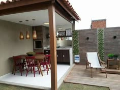 an outdoor kitchen and dining area is shown in this backyard setting with wooden decking