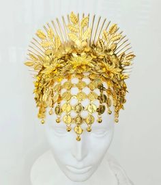 This headpiece is made of bright yellow gold metal parts (a bit warmer gold than in the pictures). It includes a forehead net with coins and tiny bells, and a 3D flower arrangement with spikes and leaf branches above it. It sits on a wide headband and will have an elastic connecting its edges unless you prefer not to have it. The headdress is quite shiny due to the golden colour of the metal, but additional accents canbe created by crystal application (including Swarovski crystals - please conta Gold Teardrop Crown Headpiece For Festival, Gold Structured Crown Headpiece For Festival, Gold Ceremonial Headpiece With Round Crown, Gold Crown Headpieces For Festival, Handmade Gold Headpiece With Teardrop Crown, Gold Ceremonial Headpiece With Tall Crown, Gold Goddess Headpieces For Wedding, Gold Goddess Wedding Headpieces, Gold Tall Crown Headpiece Handmade