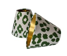 two green and white lampshades with gold rims, one in the shape of a leopard print