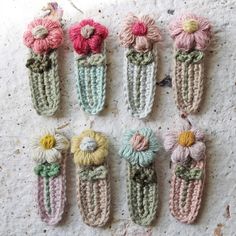 six crocheted flower clips are arranged in rows