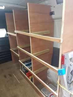 the inside of a van with wooden shelves and tools in it's storage area