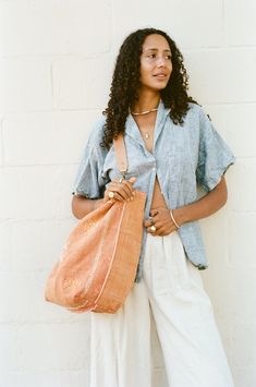 DIMENSION Oversized tote, dimensions vary COLOR Peach, orangey-pink MATERIAL Cactus silk, cotton lining, natural leather strap Orange Bucket Bag For Travel, Casual Orange Tote Bucket Bag, Orange Bohemian Bags For Spring, Spring Bohemian Orange Bag, Bohemian Orange Bags For Spring, Summer Reversible Shoulder Bag, Orange Summer Tote Shoulder Bag, Chic Orange Bucket Bag Tote, Orange Tote Shoulder Bag For Summer