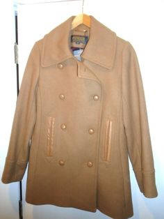 Pendleton Wool Blend Camel Tan Double Breasted Peacoat two lower hand-warmer pocket with leather trim 80% Wool / 20% Nylon Coat is fully lined Color: listed on the tag as Camel Tan Double Breasted with leather buttons front Closure includes extra buttons Size: Size 10  shoulder to shoulder measures 16 inches straight across armpit to armpit measures 21 inches straight across jacket is 30 inches long (measured from the back of the neck) sleeve measures 25 inches (from the shoulder seam to the cuf Pendleton Wool, Hand Warmers, Leather Trims, Vest Jacket, Size 10, Double Breasted, Wool Blend, Trim, Women Accessories