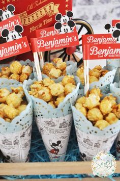 small cups filled with popcorn sitting on top of a blue tray next to each other