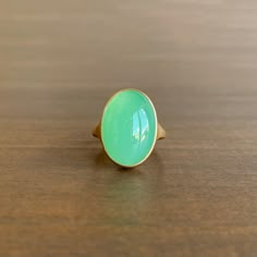 An enchanting combination of glowing green chrysoprase and sumptuous yellow gold. 18k yellow gold Chrysoprase, 10.85 carats, 12mm x 17mm (1/2" x 11/16") Green Oval Chalcedony Rings, Oval Green Chalcedony Rings, Yellow Gold Emerald Chrysoprase Cabochon Ring, Gold Oval Chrysoprase Emerald Ring, Yellow Gold Chrysoprase Cabochon Ring, Chrysoprase Jewelry, Chrysoprase Ring, Chalcedony Ring, Green Chalcedony