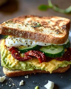 a sandwich with egg, cucumber and tomato on it