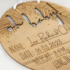 a wooden ornament with the name and date engraved on it