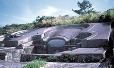 an unusual building made out of concrete on top of a hill