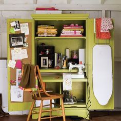 a green cabinet filled with lots of clutter and crafting supplies next to a wooden chair