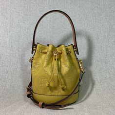 Brand New Never Been Carried Golden Sunset T Monogram Perforated Mini Bucket Bag By Tory Burch. This Bag Is Made Of Yellow Genuine Leather Dimensions: 7.2” Wide X 5.6” Tall Center X 3.3" Deep. Handle 3" Drop Long Leather Strap Is Adjustable And Detachable Strap And Handle Are In Tan Leather Drawstring Top Closure Interior: Single Compartment Microsuede Lining. Tt Logo Embossed On Bag Base Gold Tone Metalware. Yellow Bucket Bag With Adjustable Strap, Luxury Yellow Crossbody Bag, Yellow Crossbody Bucket Bag With Detachable Strap, Luxury Yellow Crossbody Shoulder Bag, Yellow Travel Bucket Bag, Yellow Bucket Bag With Gold-tone Hardware, Yellow Leather Crossbody Bucket Bag, Yellow Adjustable Strap Pouch Bucket Bag, Elegant Yellow Bucket Bag With Removable Pouch