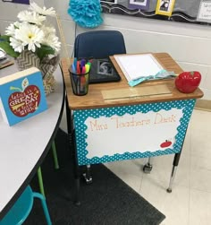 a desk with an apple on it in front of a bulletin board that says mini teacher's desk