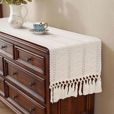 a white table cloth on top of a dresser