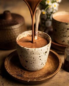 chocolate being poured into a cup on a plate