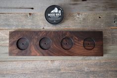 three wooden knobs are placed next to each other on a wood paneled wall