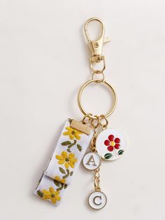 a keychain with flowers and letters on it