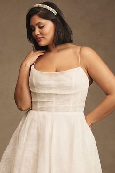 a woman in a white dress is posing for the camera with her hands on her hips