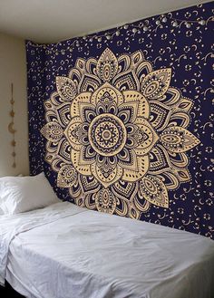 a bed sitting under a blue and yellow wall hanging