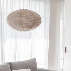 a living room with a gray couch and white curtains