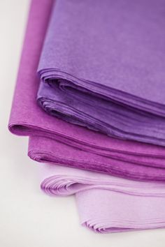 purple and lavender colored sheets stacked on top of each other