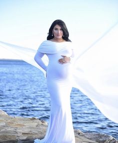 Our Sexy Mama Maternity Ruched Fold Over Flare Gown is the perfect photoshoot or special event maternity gown! With a slim fit bodice, a simple flare, and a premium stretch material this gown is equal parts comfort and elegance. This flared maternity gown is sure to wow!   #SexyMamaMaternity #maternitygown #maternitydress #bestmaternity #maternitybrands #maternityshoot #maternitysession #materntiyphotoshoot Elegant Fitted Maternity Dress With Ruffles, Fitted Long Sleeve Maternity Dress With Ruffles, Spring Fitted Maternity Gown, Fitted Floor-length Maternity Gown, Floor-length Blue Maternity Gown, Baby Shower Gown, Maternity Brands, Maternity Gown, Flare Gown