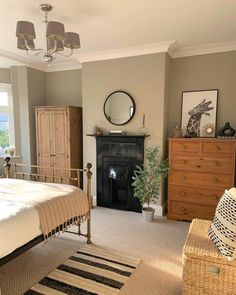 a bedroom with a bed, dressers and a mirror on the wall above it