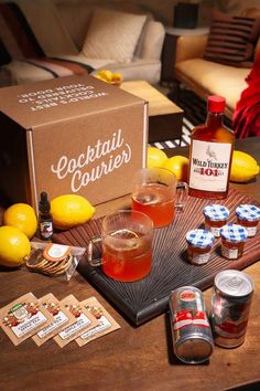 a wooden table topped with bottles of alcohol next to lemons and other food items