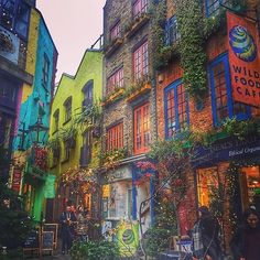 an alleyway with many colorful buildings and plants growing on it