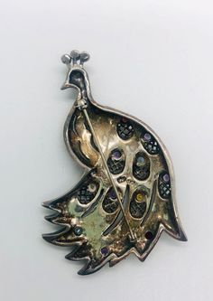 Large magnificent vintage sterling silver gemstone PEACOCK brooch. Heavy sterling silver metal in a large peacock design with marcasites and set with real gemstones. Peridot,amethyst,two colors of topaz and garnets. My pictures do. It do this beauty justice at all. Lovely beaded edged openwork in the feathers. Fully marked and acid tested as sterling silver. Measures 2 7/8 inches tall by 1 7/8 inches wide. Weighs 23gms. In excellent vintage condition condition with minimal age appropriate wear. Antique Silver Multi-stone Brooches, Silver Multi-stone Brooches, Formal Silver Multi-stone Brooches, Vintage Silver Jewelry With Peacock Design, Peacock Brooch, Interchangeable Earrings, Sterling Silver Owl, Vintage Designer Jewelry, Vintage Fine Jewelry