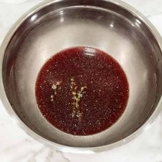 a metal bowl filled with red liquid on top of a white counter