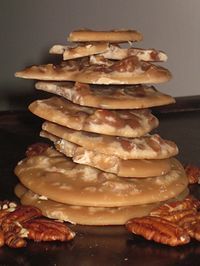 a stack of cookies with pecans on the side