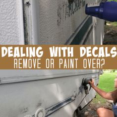 a woman is painting the side of a white truck with words that read, dealing with decals remove or paint over?