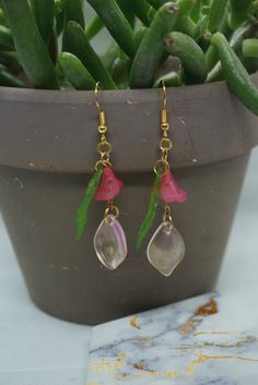 pink glass beads of a flower green leaf and pink petal Pink Dangle Jewelry With Flower Decoration, Pink Flower Decoration Drop Earrings, Pink Flower Beaded Earrings For Gift, Pink Teardrop Flower Earrings With Ear Wire, Pink Flower Earrings With Ear Wire, Pink Beaded Resin Jewelry, Pink Flower Decoration Dangle Jewelry, Handmade Pink Teardrop Flower Earrings, Pink Flower Earrings With Resin And Ear Wire